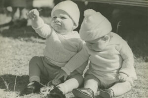 Two Little Babies Sitting On Grass Wearing Caps And Jumpers 6" x 4" Photo Print