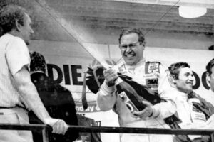 Allan Moffat spraying champagne on podium 6" x 4" Photo Print